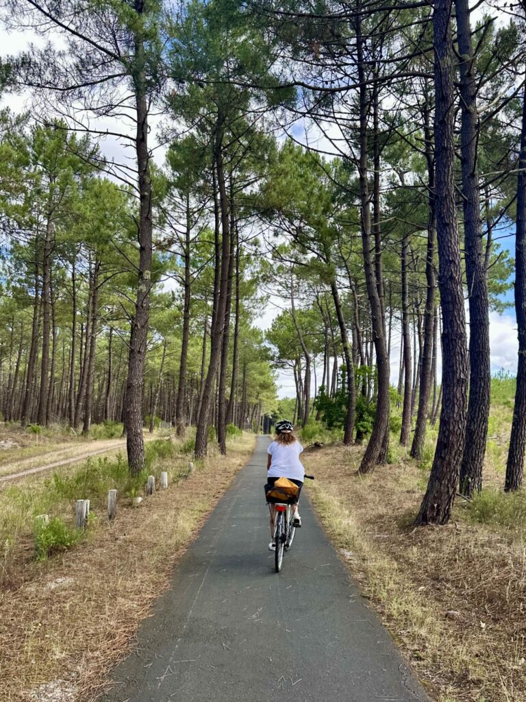Sabine à vélo au cœur de la forêt médocaine sur la Vélodyssée.