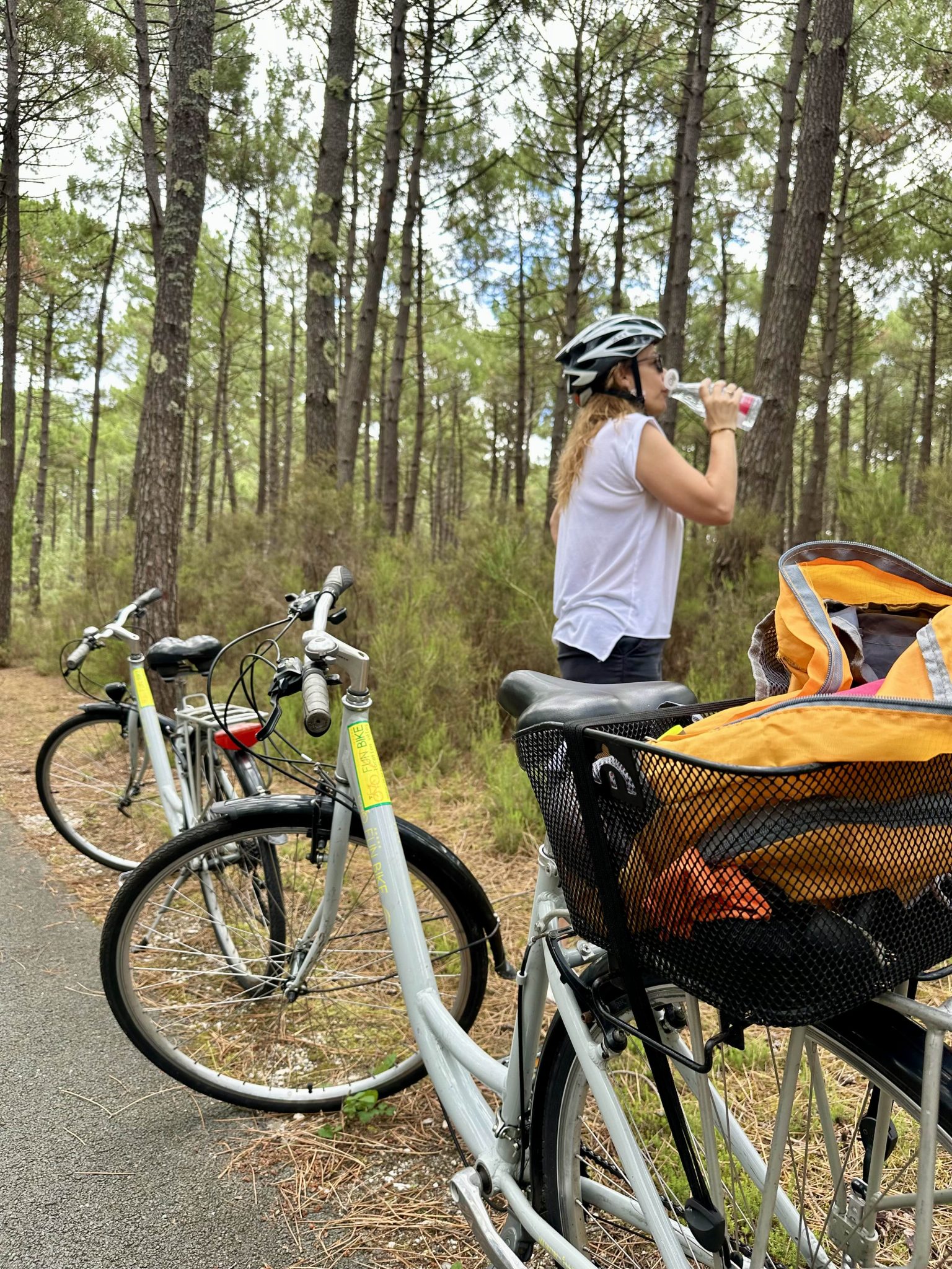 Sabine fait une pause pour boire de l’eau lors d’une balade à vélo en forêt.