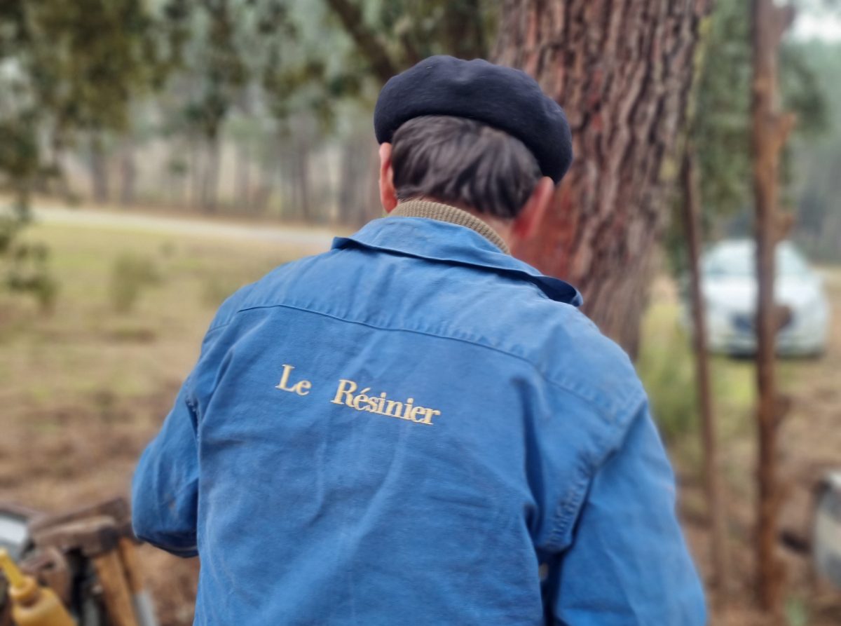 Homme de dos avec un bleu de travail avec écrit